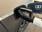 Real-world close-up of the GB/T charging gun connected to the CCS2 adapter at a vehicle inlet