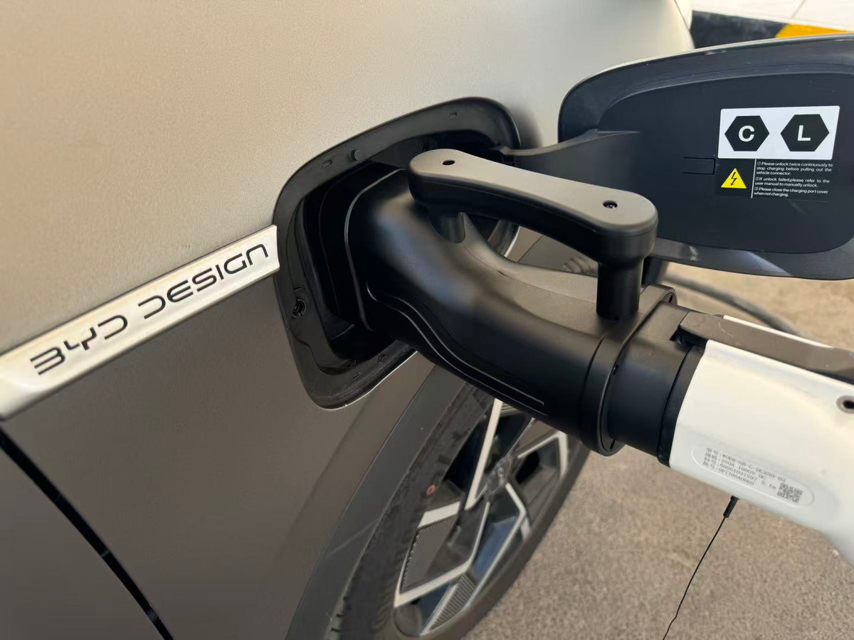 Real-world close-up of the GB/T charging gun connected to the CCS2 adapter at a vehicle inlet