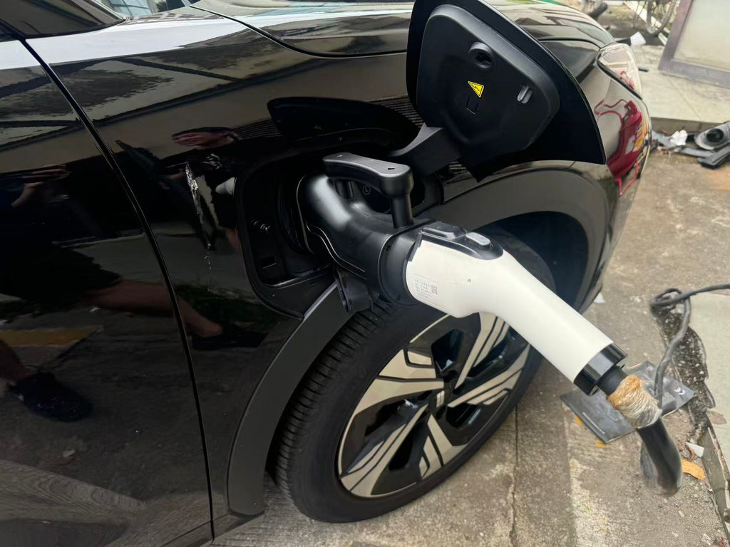 GB/T to CCS2 adapter connected between a charging gun and a vehicle inlet; compatibility must be checked for the exact vehicle